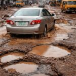 Car hitting a pothole on a rough Nigerian road