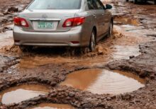 Car hitting a pothole on a rough Nigerian road